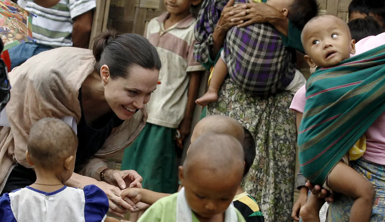 Utusan khusus UNHCR, Angelina Jolie menyapa seorang anak saat mengunjungi kamp pengungsian etnis Kachin di Jam Mai Kaung IDP, Myitkyina, Myanmar, Rabu (30/7/2015). (REUTERS/Soe Zeya Tun)