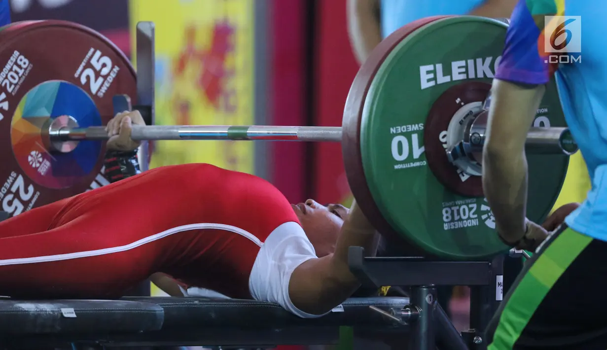 Atlet Para Powerlifting Indonesia, Ni Nengah Widiasih saat melakukan angkatan pada Asian Para Games 2018 di Jakarta, Minggu (7/10). Ni Nengah berhasil menyumbang perak perdana untuk Indonesia di Asian Para Games 2018. (Liputan6.com/Helmi Fithriansyah)