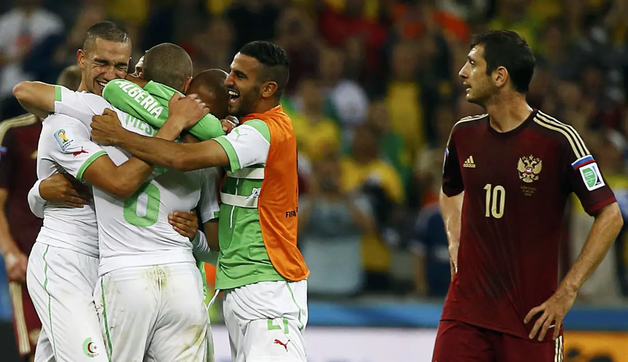 Gelandang Timnas Rusia, Alan Dzagoev (kanan), tertegun menyaksikan selebrasi pemain Aljazair di laga penutup penyisihan Piala Dunia Grup H di Stadion Baixada, Curitiba, Brasil, (27/6/2014). (REUTERS/Damir Sagolj)