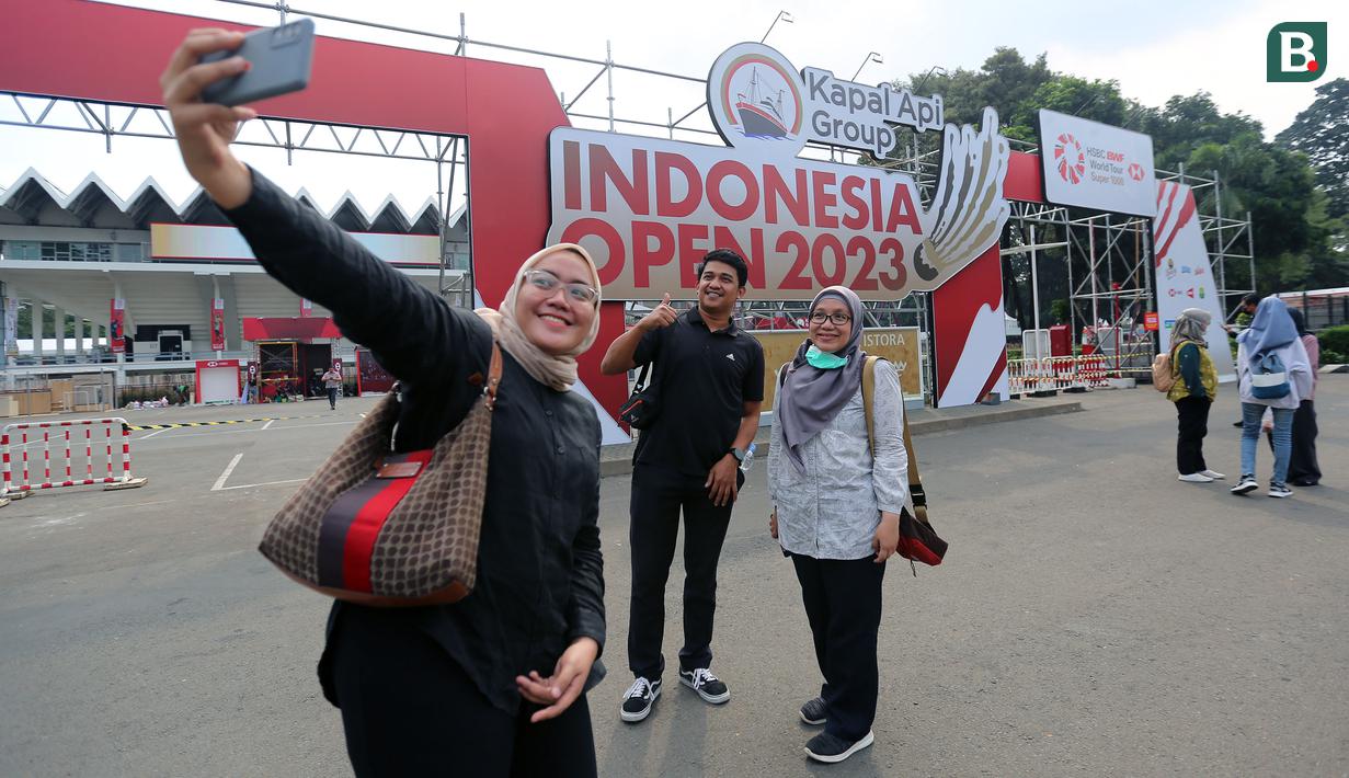 <p>Sejumlah pengunjung melakukan swafoto di pintu gerbang Istora Senayan menjelang Indonesia Open 2023 pada Senin (12/06/2023). Ketua Panpel Armand Darmadji mengungkapkan bahwa tahun ini akan menjadi edisi terakhir turnamen BWF Super 1000 tersebut di Istora Senayan sebelum dipindahkan ke arena yang lebih besar yakni Indoor Multifunction Stadium. (Bola.com/Bagaskara Lazuardi)</p>