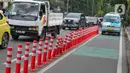 Kendaraan bermotor melintas di samping stick cone pembatas jalur sepeda di Kawasan Jalan Penjernihan Jakarta, Sabtu (10/12/2022). Keadaan stick cone untuk pembatas jalur sepeda tersebut terlihat sudah rusak dan tidak terpasang dengan benar. (Liputan6.com/Angga Yuniar)
