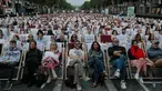 Orang-orang menonton film gratis yang diputar di ruang terbuka di jalan Champs Elysees, Paris (7/7/2019). Pemutaran bioskop luar ruangan gratis di Paris musim panas ini menayangkan film Prancis dengan teks bahasa Inggris, untuk membantu Anglophones mengikuti budaya Prancis. (AP Photo/Michel Euler)