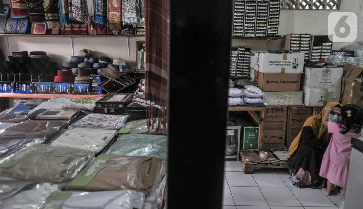 Keluarga Edi saat berada di toko oleh-oleh haji miliknya di Jalan Raya Pondok Gede, Jakarta, Rabu (21/7/2021). Saking sepinya, Edi terpaksa menutup 3 tokonya lantaran tak mampu membayar sewa kontrakan dan mensiasati dengan menjual masker agar dapat mencukupi kebutuhan sehari-hari. (merdeka.com/Iqbal