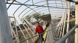 Pejalan kaki melintasi Jembatan Penyeberangan Orang (JPO) Jayakarta di Jakarta, Rabu (25/10). Untuk menjaga keamanan dan mencegah tawuran, warga memberlakukan jam buka tutup pada JPO tersebut. (Liputan6.com/Immanuel Antonius)