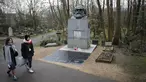 Pengunjung berjalan dekat makam filsuf ternama Jerman dan tokoh sosialisme, Karl Marx, di Pemakaman Highgate, London, Selasa (5/2). Nisan peringatan terbuat dari marmer yang menandakan persemayaman Marx dirusak oleh orang tidak dikenal. (Tolga AKMEN/AFP)