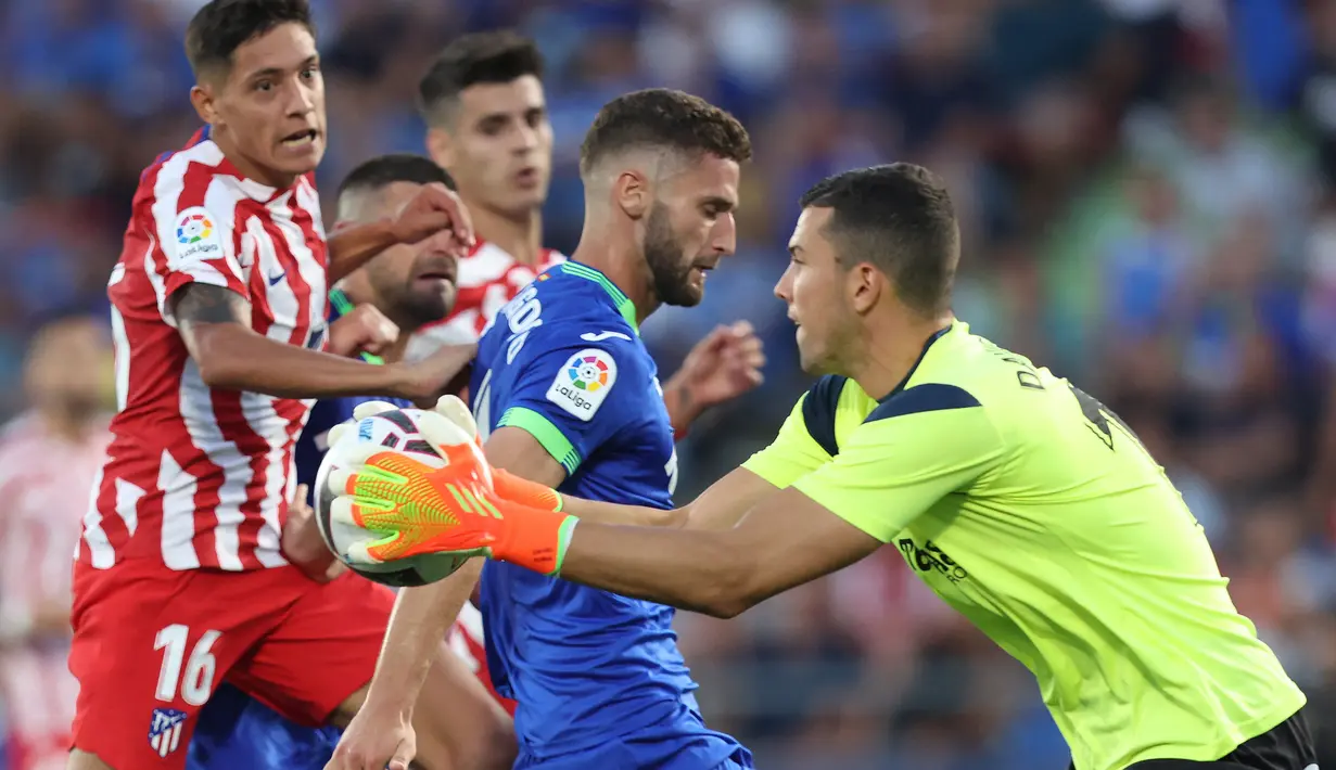 Penjaga gawang Getafe David Soria (kanan) melakukan penyelamatan saat pemain Atletico Madrid Nahuel Molina (kiri) mendekat pada pertandingan sepak bola Liga Spanyol di Stadion Alfonso Perez Coliseum, Getafe, Spanyol, 15 Agustus 2022. Atletico Madrid menang 3-0. (Thomas COEX/AFP)