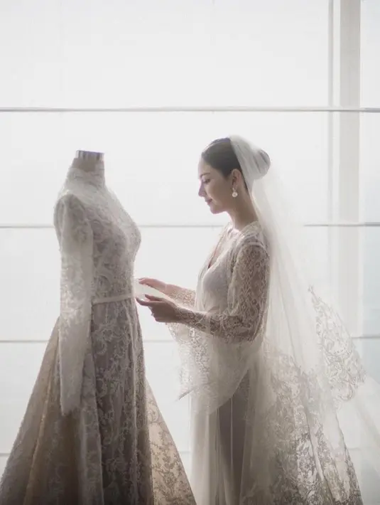 Gaun pengantin dengan kerah tinggi dan full renda yang disulam dengan tangan. Dan membutuhkan waktu 1.200 jam untuk pengerjaan sampai selesai. [Foto: Instagram @bridestory]