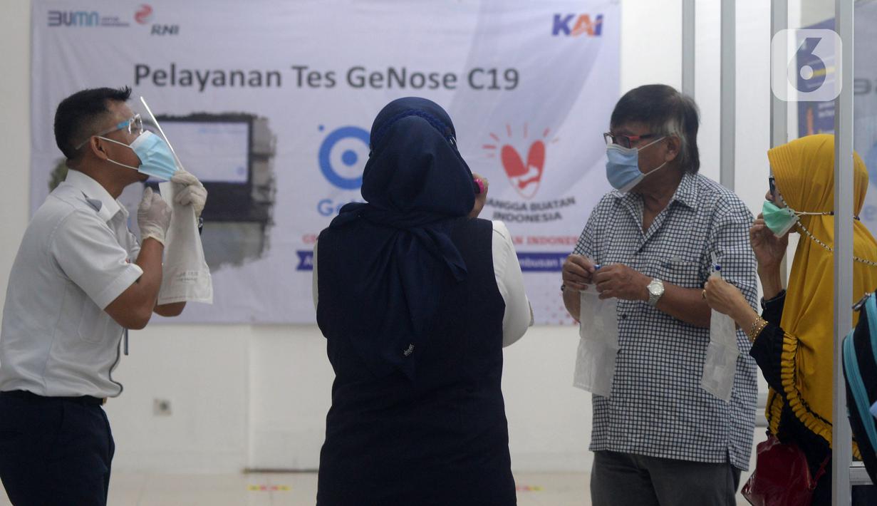 Petugas mengajari calon penumpang untuk tes COVID-19 dengan GeNose C19 di Stasiun Pasar Senen, Jakarta, Selasa (23/2/2021). Hasil tes tersebut kemudian menjadi dokumen syarat perjalanan para penumpang kereta. (merdeka.com/Imam Buhori)