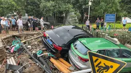 Mobil-mobil yang rusak bertumpuk pada puing-puing setelah hujan lebat melanda kota Zhengzhou yang menyebabkan banjir di provinsi Henan, China tengah (21/7/2021). Luapan sungai menggenangi jalan-jalan dan membuat kendaraan terbawa arus setelah curah hujan 200 mm turun dalam satu jam. (AFP/STR)
