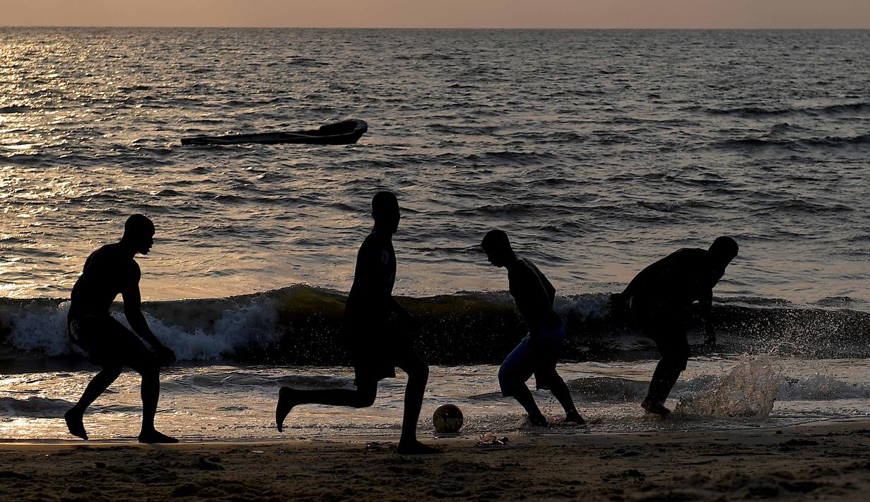 Anak-anak muda Gabon bermain sepak bola di tepian pantai  di Libreville (17/1/2017). Demam Piala Afrika 2017 menjadikan Gabon sebagai salah satu tujuan wisata sekaligus ajang mencari bakat-bakat muda Afrika.  (AFP/Gabriel Bouys)