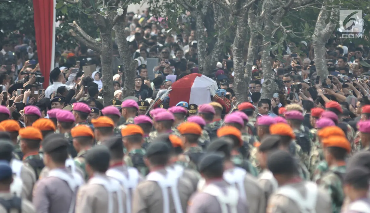 Anggota Paspampres mengusung peti jenazah almarhum Presiden ke-3 RI BJ Habibie menuju liang lahat saat tiba di Taman Makam Pahlawan (TMP) Kalibata, Jakarta, Kamis (12/9/2019). BJ Habibie meninggal pada Rabu (11/9/2019) pukul 18.05 WIB setelah menjalani perawatan di RSPAD. (merdeka.com/Iqbal Nugroho)