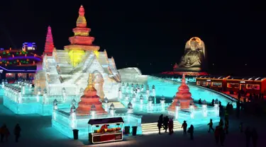 Sejumlah orang mengunjungi Harbin Ice-Snow World di Harbin di provinsi Heilongjiang, Tiongkok (2/1). Bangunan atau istana yang terbuat dari balok es ini dipenuhi cahaya yang berwarna-warni. (AFP Photo/China Out)