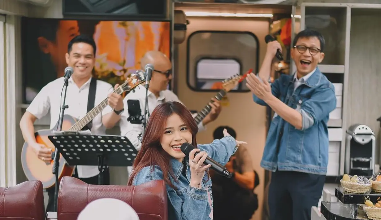 Penampilan Brisia Jodie pakai denim on denim saat nyanyi di dalam kereta api. Ia memadukan jaket jeans dengan celana panjang yang juga jeans. [Foto: Instagram/brisiajodie96]