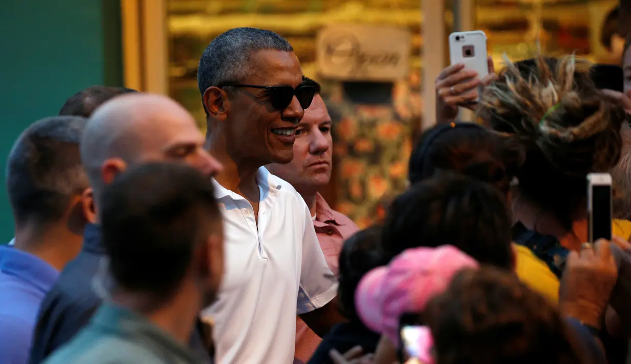 Presiden AS Barack Obama berbincang dengan warga setelah mengantre untuk membeli es serut saat berkunjung ke Island Ice ketika berlibur di Kailua, Hawaii, AS, AS, (24/12). (REUTERS/Kevin Lamarque)