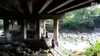 Pengendara motor melewati jembatan Ciliwung yang berada di bawah tol ruas Gadog, Ciawi, Bogor (16/68). Jembatan ini menjadi jalan alternatif bagi pemotor dari kawasan Bogor menuju arah Puncak dan Sukabumi. (Merdeka.com/Arie Basuki)