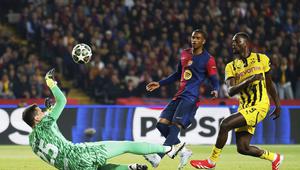 Kiper Barcelona, Wojciech Szczesny, melakukan penyelamatan dari ancaman yang dilakukan pemain Borussia Dortmund, Serhou Guirassy, dalam leg pertama perempat final Liga Champions 2024/2025 di Stadion Olimpic Lluis Companys, Kamis (10/4/2025) dini hari WIB. (AP Photo/Joan Monfort)