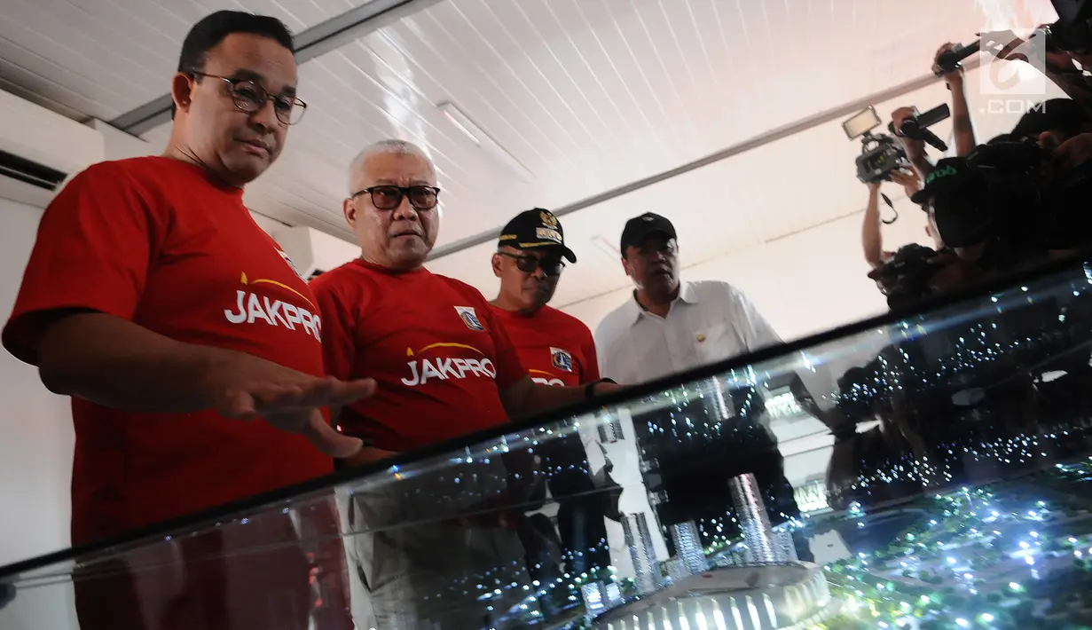 Gubernur DKI Jakarta Anies Baswedan bersama Dirut Jakpro Dwi Wahyu Daryoto melihat maket Jakarta International Stadium di Jakarta, Kamis (14/3). Stadion ini akan dibangun dengan konsep internasional. (Liputan6.com/Herman Zakharia)