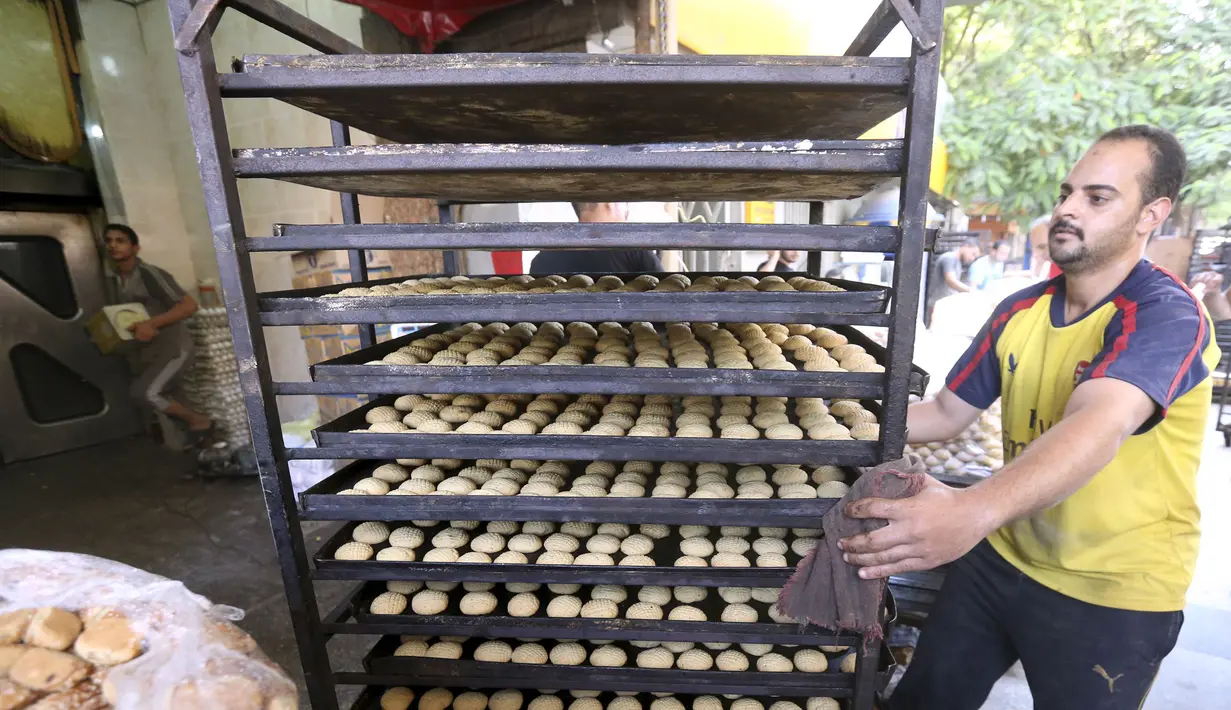Seorang pekerja membawa permen tradisional "Kahk" untuk perayaan Idul Fitri, Kairo, (27/7/14). (REUTERS/Mohamed Abd El Ghany)