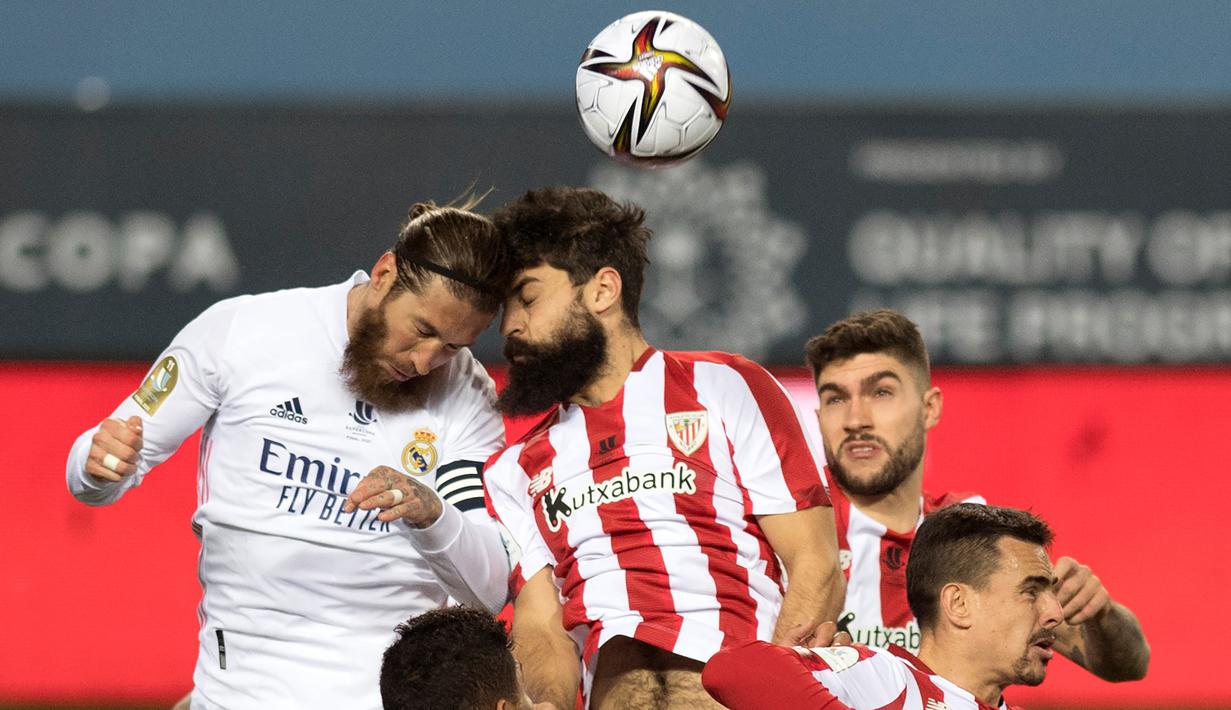 Bek Real Madrid, Sergio Ramos (kiri) berduel udara dengan striker Athletic Bilbao, Asier Villalibre dalam laga semifinal Piala Super Spanyol 2020/21 di La Rosaleda Stadium, Malaga, Kamis (14/1/2021). Real Madrid kalah 1-2 dari Athletic Bilbao. (AFP/Jorge Guerrero)