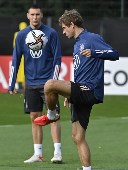 Pemain Jerman Thomas Mueller (kanan) dan Niklas Suele mengambil bagian dalam sesi latihan di Hamburg, Jerman utara, Rabu (6/10/2021). Jerman akan menjamu Rumania di matchday ketujuh Grup J Kualifikasi Piala Dunia 2022 Zona Eropa pada Sabtu, 9 Oktober dini hari. (John MACDOUGALL / AFP)