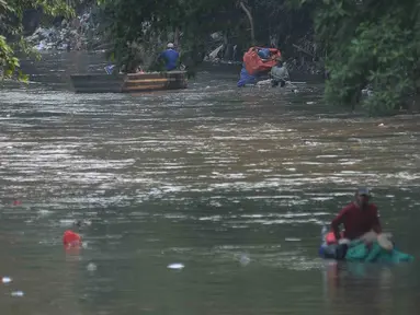 Debit air kali Ciliwung berkurang dimanfaatkan warga untuk mencari barang bekas botol plastik di Jakarta, Jumat (11/8/2023).  Hal ini dikarena debit bendungan Katulampa berkurang. Selain itu Tinggi Muka AIr (TMA di Katulampa masih berada 0 centimeter sejak awal Juni 2023. (merdeka.com/Imam Buhori)