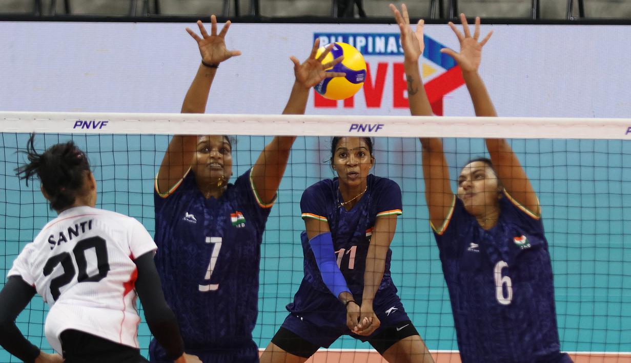 Pemain Timnas voli putri Indonesia, Junaida Santi (kiri) melepaskan spike yang berhasil menembus blok dua pemain India, Jini Kovat Shaji (tengah) dan Soorya pada laga klasifikasi peringkat 5-8 AVC Challenge Cup 2024 di Rizal Memorial Coliseum, Manila, Filipina, Selasa (28/5/2024). Indonesia kalah 1-3 (16-25, 32-30, 20-25 dan 24-26). (Asian Volleyball Confederation)