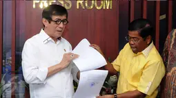 Menkumham, Yasonna H Laoly (kiri) bersama Sekjen Partai Golkar Munas Bali, Idrus Marham memperlihatkan SK Pengesahan Komposisi dan Personalia Pengurus DPP Partai Golkar 2014-2019 di Jakarta, Selasa (26/4/2016). (Liputan6.com/Helmi Fithriansyah)