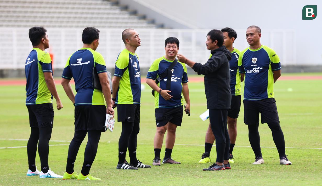 Pelatih Timnas Indonesia U-20, Indra Sjafri sedang berdiskusi dengan para asistennya pada sesi latihan di Stadion Madya, Gelora Bung Karno, Jakarta, Rabu (5/2/2025). (Bola.com/Abdul Aziz)