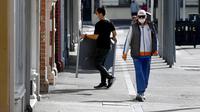 Seorang pekerja kafe melakukan aktivitas di jalan yang tenang saat kota itu mengalami penguncian keenam saat memerangi wabah varian Delta dari coronavirus.di Melbourne (25/8/2021). (AFP/William West)