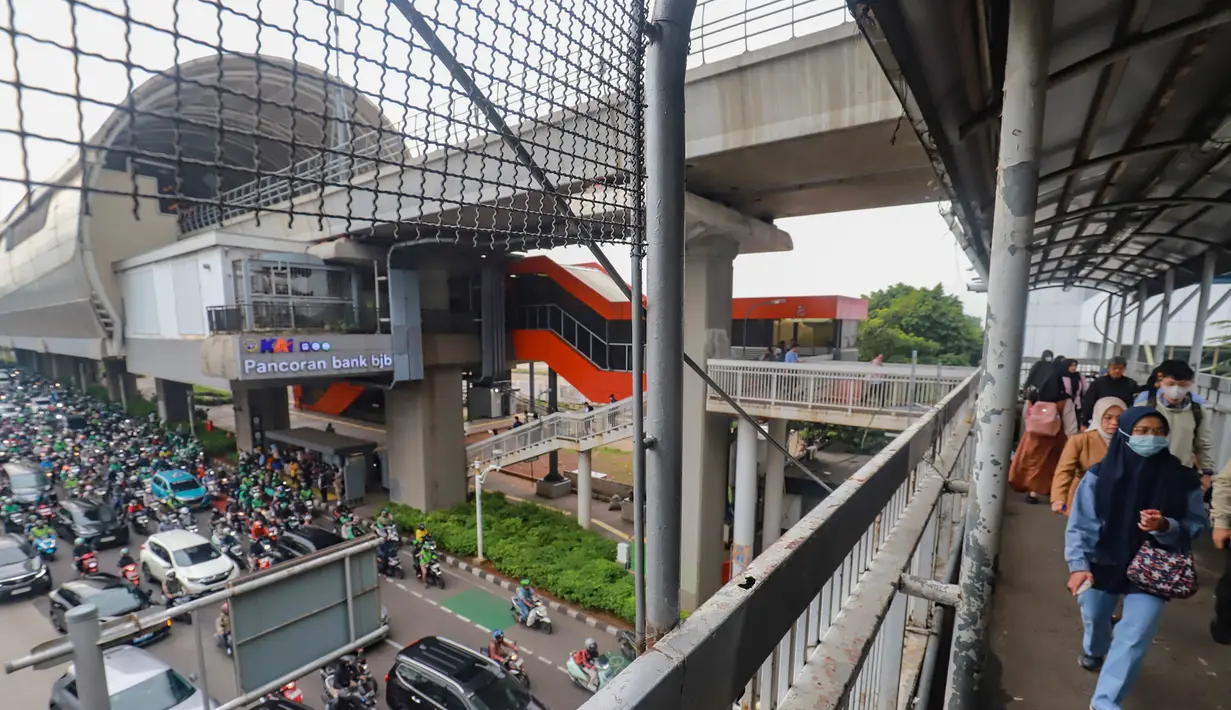 Usai jeda libur panjang perayaan Natal 2025 dan Tahun Baru 2026, sejumlah jalan utama di Jakarta kembali dipadati pengendara, baik roda dua maupun empat. Tampak dalam foto, pejalan kaki melintas di Jembatan Penyeberangan Orang (JPO) di kawasan Jalan Jenderal Gatot Subroto, Jakarta, Senin (5/1/2026). (merdeka.com/Arie Basuki)
