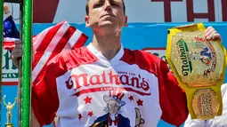 Joey Chestnut mengangkat trofi usai memenangkan Lomba Makan Hot Dog Nathans di New York, AS (4/7). Joey Chestnut menang untuk kesepuluh kalinya sekaligus mencetak rekor baru. (AP Photo/Bebeto Matthews)