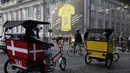 <p>Becak melewati poster raksasa yang mengumumkan Grand Depart balap sepeda 2022 di Kopenhagen, Denmark pada 28 Juni 2022. Kecintaan warga akan sepeda juga yang membuat Denmark begitu gembira menyambut Tour de France, yang akan mulai dari 01 Juli 2022. (Thomas SAMSON / AFP)</p>