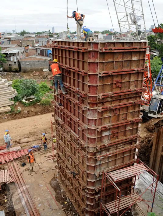 Pekerja menyelesaikan proyek pembangunan jalur dua rel ganda atau DDT Manggarai-Cikarang, Jakarta, Jumat (13/1). Kemenhub akan bekerjasama dengan Pemda DKI untuk membantu mempercepat pembebasan lahan tersebut. (Liputan6.com/Gempur M Surya)