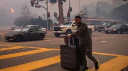 Api yang bergerak cepat juga mengancam kawasan permukiman setempat di California Selatan. (Apu Gomes/Getty Images North America/Getty Images via AFP)