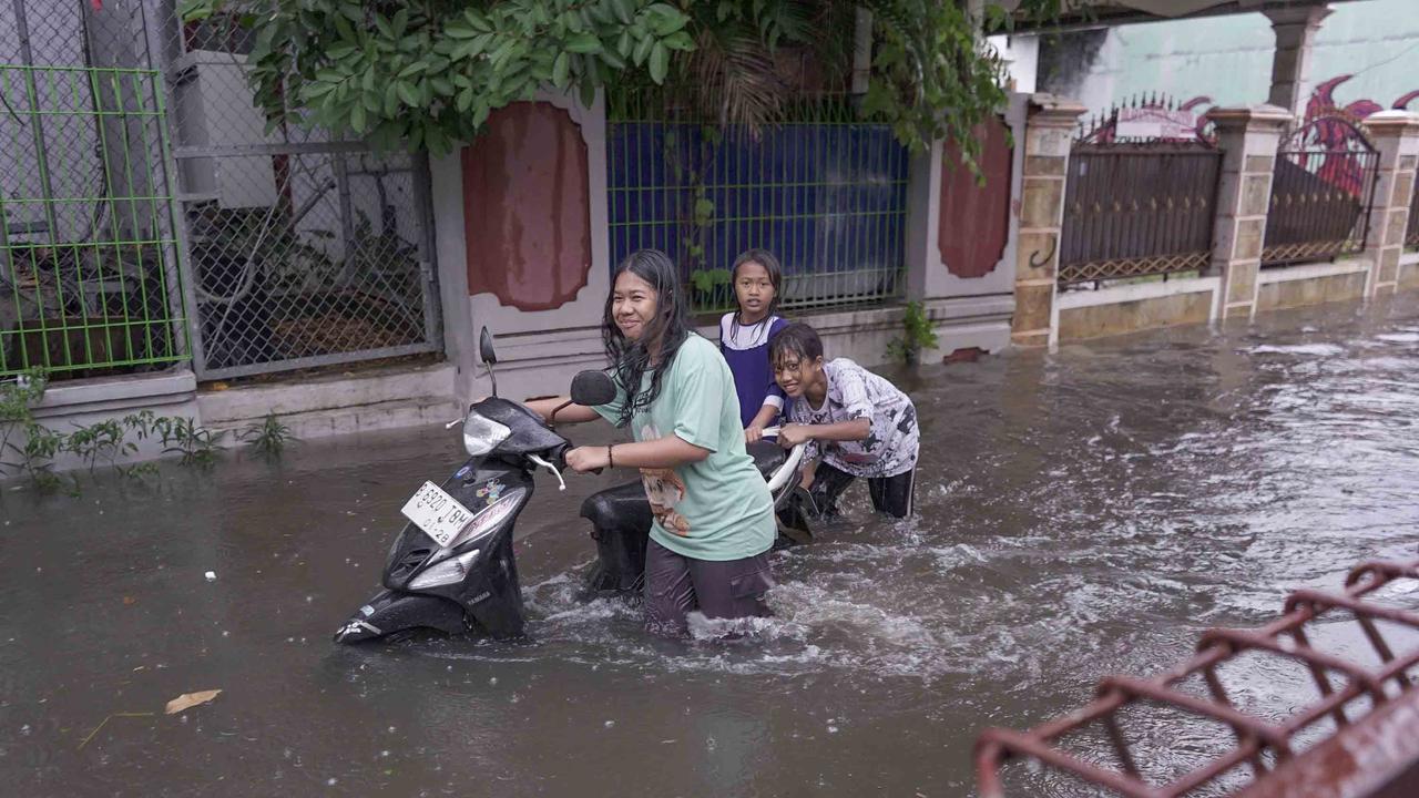 FOTO: Drainase Meluap, Warga Pasar Rebo Terobos Genangan