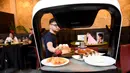 Robot mengantarkan makanan kepada pelanggan di restoran Asia di Wina, Austria, Kamis (28/5/2020). Restoran tersebut menggunakan robot untuk mengantar makanan guna mengurangi kontak yang tidak diperlukan antara pelayan dan pelanggan di tengah pandemi virus corona COVID-19. (Xinhua/Guo Chen)