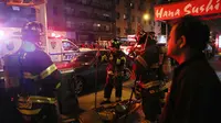 Petugas melakukan penyelidikan di lokasi terjadinya ledakan di New York, Sabtu (17/9). Diduga ledakan terjadi di tempat sampah, menghancurkan jendela gedung yang berada di dekatnya. (AFP PHOTO)