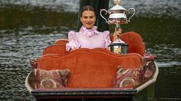 Aryna Sabalenka dari Belarusia berpose dengan trofi kejuaraan tenis Australia Open 2023 di atas gondola di Royal Botanic Garden di Melbourne (29/1/2023). Kemenangan ke-11 berturut-turut tahun ini juga membawa Sabalenka kembali ke peringkat kedua WTA di belakang Iga Swiatek dari Polandia. (AP Photo/Aaron Favila)