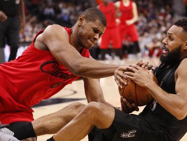 Pemain San Antonio Spurs, Patty Mills (kanan) berebut bola dengan pemain Chicago Bulls, Cristiano Felicio (kiri) pada lanjutan laga NBA di AT&T Center, (25/12/2016). (Reuters/Soobum Im-USA TODAY Sports)