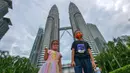 Anak-anak yang mengenakan masker berpose untuk difoto di depan Menara Kembar Petronas di Kuala Lumpur, Malaysia, pada 3 Oktober 2020. Malaysia melaporkan tambahan 317 kasus terkonfirmasi COVID-19 pada Sabtu (3/10), sehingga totalnya bertambah menjadi 12.088. (Xinhua/Chong Voon Chung)