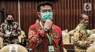 Mentan Syahrul Yasin Limpo mengenakan kalung bertuliskan anti virus corona saat raker dengan Komisi IV DPR di Kompleks Parlemen, Senayan, Jakarta, Selasa (7/7/2020). Rapat membahas program strategis kementerian dalam rangka percepatan pemulihan ekonomi dampak COVID-19. (Liputan6.com/Johan Tallo)