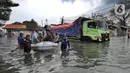 Petugas mengevakuasi warga dengan perahu karet saat banjir rob di kawasan Pelabuhan Sunda Kelapa, Jakarta, Selasa (7/12/2021). Banjir rob setinggi satu meter memutus Jalan Kerapu yang menghubungkan Ancol-Pluit. (merdeka.com/Arie Basuki)