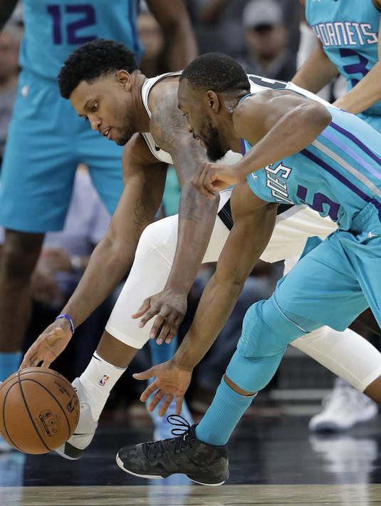 Pemain San Antonio Spurs, Rudy Gay (kiri) berebut bola dengan pemain Charlotte Hornets, Kemba Walker pada laga NBA basketball game di AT&T Center, San Antonio, (3/11/2017) waktu setempat. San Antonio menang 108-101. (AP/Eric Gay)