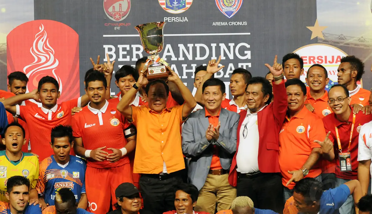 Mantan Gubernur DKI Jakarta, Sutiyoso mengangkat piala Trofeo Persija usai gelaran di Stadion GBK Jakarta, (11/1/2015). Persija Jakarta, Arema Cronus dan Sriwijaya FC menjadi juara bersama di Trofeo Persija. (Liputan6.com/Helmi Fithriansyah)
