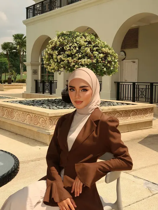 Tampil elegan dengan padu padan loose dress, puffed blazer, dan hijab segi empat yang dililit ke belakang. [@nuin.azahari]
