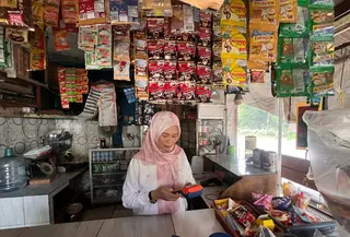 Popon Fatima Saat Melayani Transaksi di Warungnya (Supriatin/Liputan6.com)