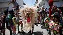 Sejumlah orang menari sambil mengenakan kostum dan topeng saat perayaan tradisional di Naiguata, Venezuela (31/5). Sejumlah orang kerasukan dan menari selama festival yang dikenal Dancing Devils ini di Naiguata. (AP/Arian Cubillos)