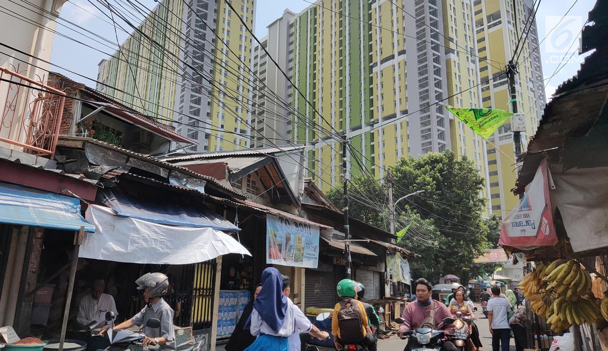 Pengendara sepeda motor melintas dekat proyek Rusunawa Pasar Rumput yang hampir selesai pengerjaannya di Jakarta, Selasa (16/7/2019). Proyek yang dimulai sejak 2016 lalu tersebut memiliki 1.984 unit hunian serta 1.314 kios. (Liputan6.com/Immanuel Antonius)