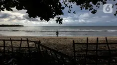 Seseorang terlihat di pantai Carita, Pandeglang, Banten, Selasa (18/1/2022). Objek wisata Pantai Carita yang menjadi tempat favorit pengunjung kini tampak sepi seusai gempa beberapa waktu lalui dan juga lantaran naikknya kasus virus covid 19 varian omicron. (Liputan6.com/Johan Tallo)