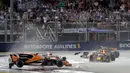 Mobil pembalap McLaren Fernando Alonso, melayang setelah bertabrakan dengan pembalap Ferrari, Kimi Raikkonen pada awal Grand Prix Singapura Formula One di Sirkuit Marina Bay City, Singapura, Minggu, (17/09). (AP Photo / Wong Maye-E)